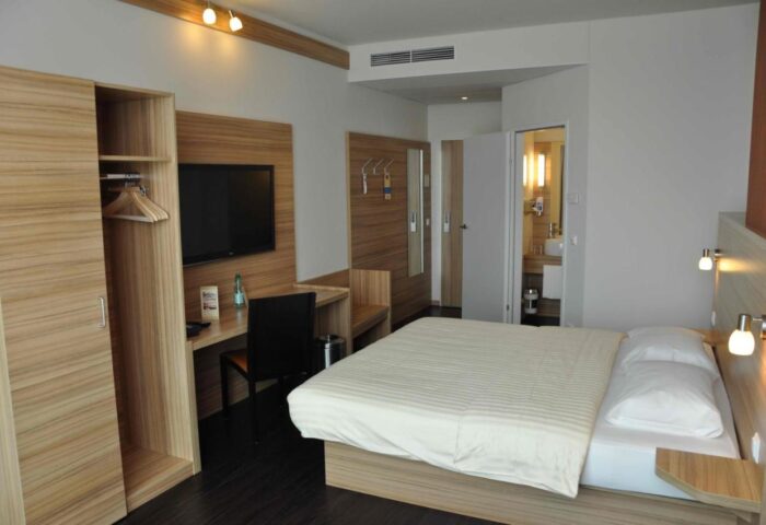 Star Inn Hotel Wien Schönbrunn room. Gay-friendly hotel with bed, desk, TV, closet, and bathroom. Modern design for gay travelers.