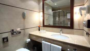Starhotels Ritz gay-friendly hotel bathroom. Sink, mirror, shower, and toilet. Gay travel-friendly accommodations.