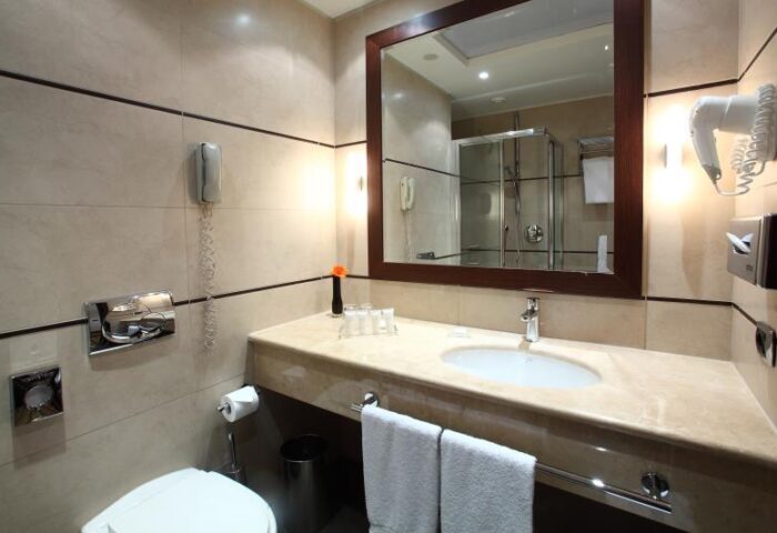 Starhotels Ritz gay-friendly hotel bathroom. Sink, mirror, shower, and toilet. Gay travel-friendly accommodations.