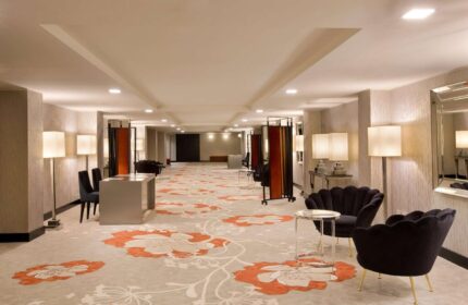 Starhotels Ritz: Hotel lobby featuring floral carpet, stylish seating, and warm lighting. A gay-friendly hotel for your travel needs.