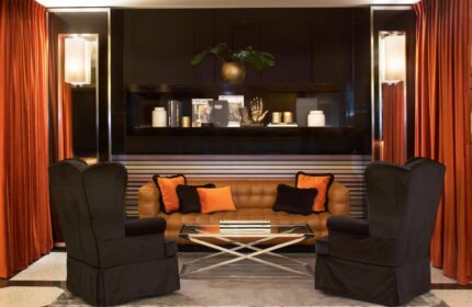 Starhotels Ritz, a gay-friendly hotel. Lounge area with armchairs, a sofa, and a coffee table. Upscale interior design in a luxury hotel.
