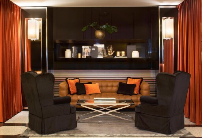 Starhotels Ritz, a gay-friendly hotel. Lounge area with armchairs, a sofa, and a coffee table. Upscale interior design in a luxury hotel.