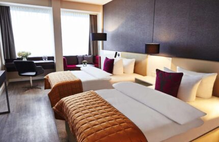 Steigenberger Hotel Koln room. Gay-friendly hotel in Cologne, Germany. Two beds, desk, and sitting area. Modern design, comfortable for gay travelers.