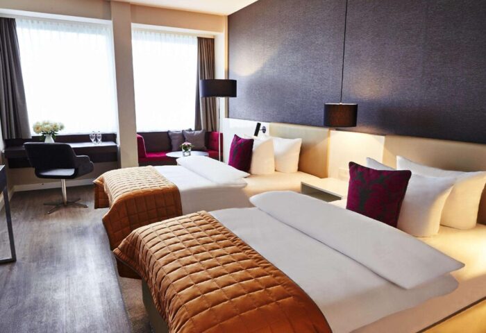 Steigenberger Hotel Koln room. Gay-friendly hotel in Cologne, Germany. Two beds, desk, and sitting area. Modern design, comfortable for gay travelers.