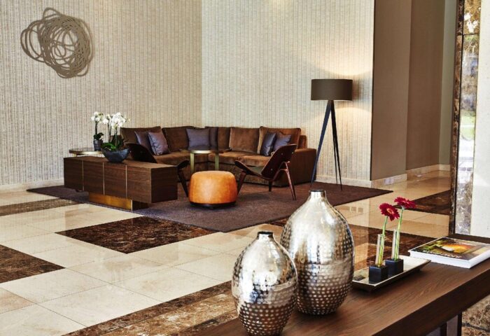 Steigenberger Hotel Köln lobby interior. Gay-friendly hotel with modern design, brown sofa, stylish vases, and warm lighting. Perfect for gay travel.