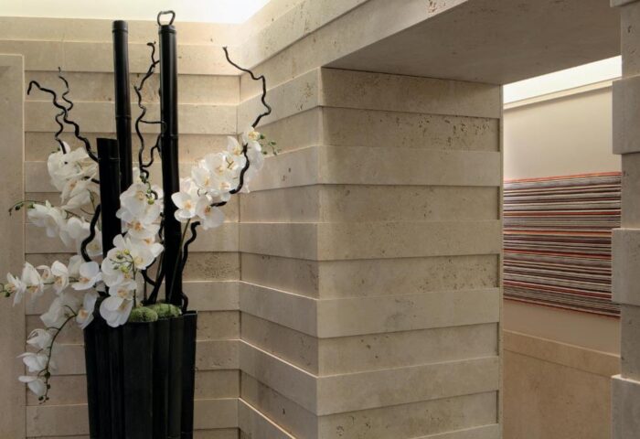 Stendhal Luxury Suites' gay-friendly hotel decor. Interior design featuring stone walls, black bamboo, and white orchids. Elegant suite detail.