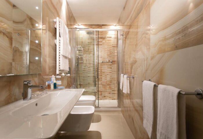 Bathroom at Stendhal Luxury Suites, a gay-friendly hotel. Features a modern sink, shower, and marble walls. Ideal for gay travelers.