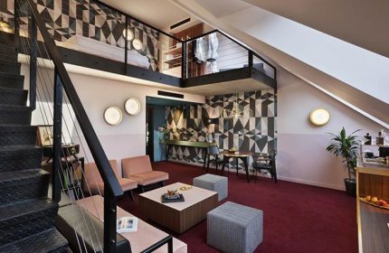 Stories Hotel Budapest room interior. Gay-friendly hotel with loft, geometric wallpaper, & modern design. Ideal for gay men travel in Budapest.