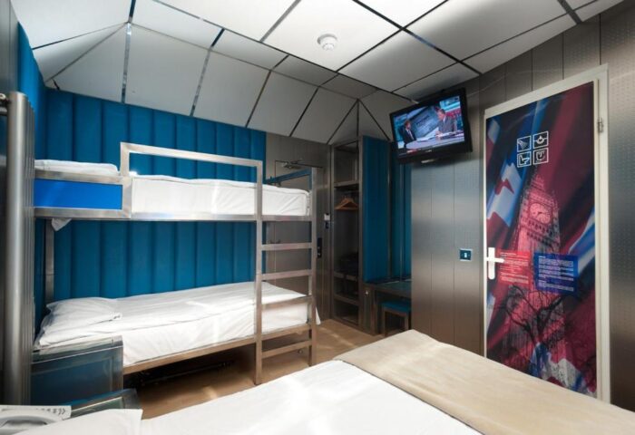 Stylotel, a gay-friendly hotel. Bunk beds, TV, and door with a Big Ben design. Modern interior. Ideal for gay men travel in style.