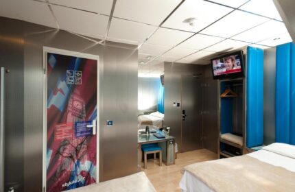 Stylotel, gay-friendly hotel room. Modern design with London themed door art, TV, and sleek furniture. Ideal for gay travel in the city.