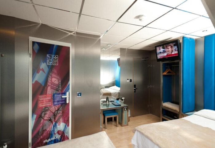 Stylotel, gay-friendly hotel room. Modern design with London themed door art, TV, and sleek furniture. Ideal for gay travel in the city.