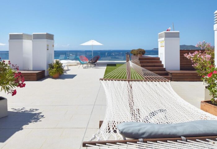 Rooftop at Sud Ibiza Suites, a gay-friendly hotel. Hammock, lounge chairs, and ocean views. Ideal for gay travel in Ibiza.