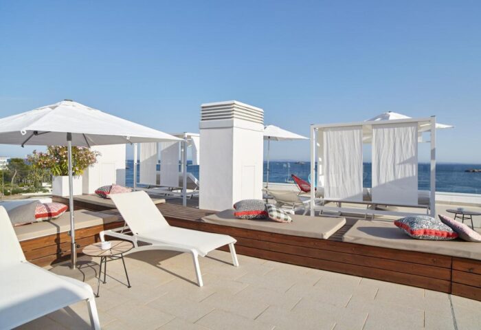 Sud Ibiza Suites gay-friendly hotel rooftop. Loungers, parasols, and cabanas offer stunning sea views. Ideal for gay travelers in Ibiza.