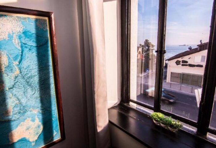 Sunset Destination Hostel's gay-friendly room view. Window with ocean view, map on the wall. Great gay travel lodging in Lisbon.