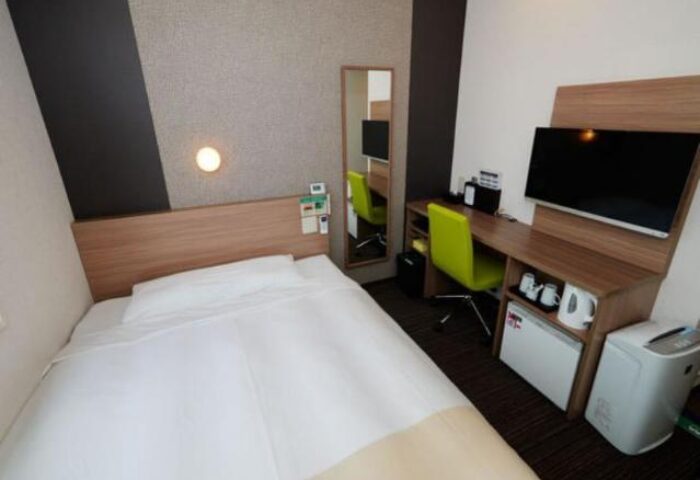 Super Hotel Shinjuku Kabukicho room. Gay-friendly hotel with bed, desk, TV, mini-fridge, and air purifier. Modern, compact design.