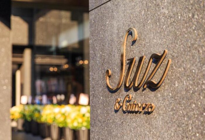 Suz Hotel logo on building. Gay-friendly hotel with modern design. A great travel destination for gay men seeking style and comfort.