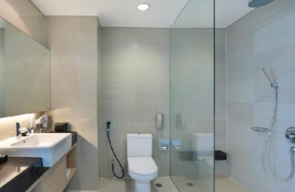 Swiss-Belhotel Mangga Besar bathroom. Modern design with sink, toilet, and shower. Gay-friendly hotel in Jakarta, Indonesia.