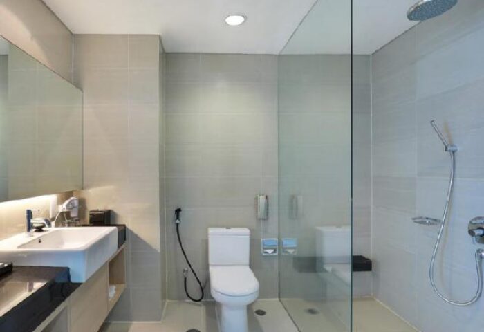 Swiss-Belhotel Mangga Besar bathroom. Modern design with sink, toilet, and shower. Gay-friendly hotel in Jakarta, Indonesia.