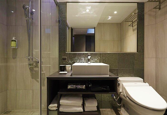 TANGO INN TAIPEI XIMEN gay-friendly hotel bathroom. Features a modern sink, toilet, shower, and large mirror in a well-lit, stylish space.