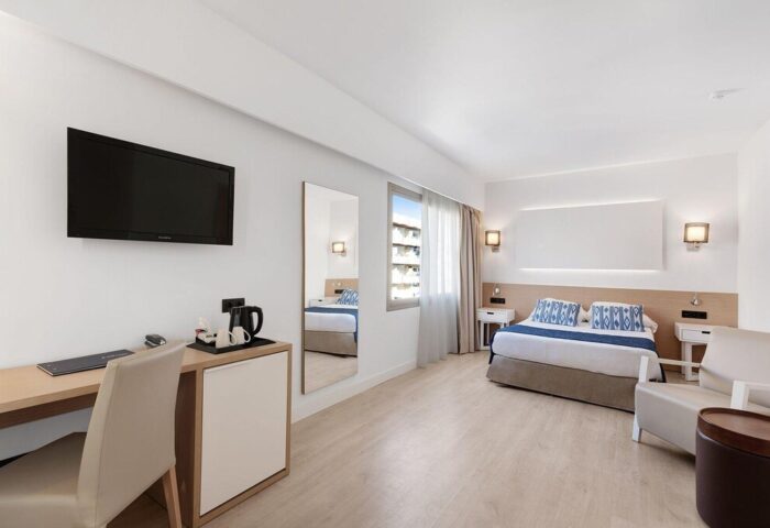 THB Los Molinos Adults Only gay-friendly hotel room. Modern design, desk, TV, king bed, accent pillows, and a chair. Clean, bright, and inviting.