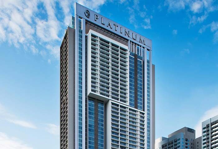 THE FACE Suites Kuala Lumpur, a gay-friendly hotel. Exterior view of the Platinum Suites building against a blue sky.