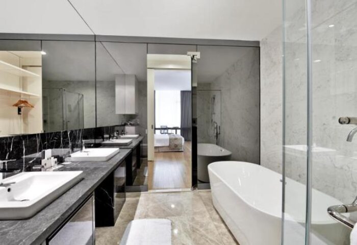 THE FACE Suites Kuala Lumpur gay-friendly hotel bathroom. Modern design with tub, sinks, and marble accents. Perfect for LGBTQ travelers.