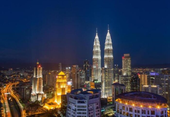 Night view of Kuala Lumpur skyline from THE FACE Suites, a gay-friendly hotel. Features Petronas Towers and city lights.