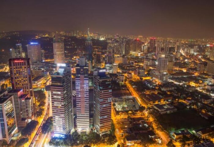 Night view of THE FACE Suites Kuala Lumpur, a gay-friendly hotel. Cityscape with bright lights, skyscrapers, & urban landscape. Great for gay travel.