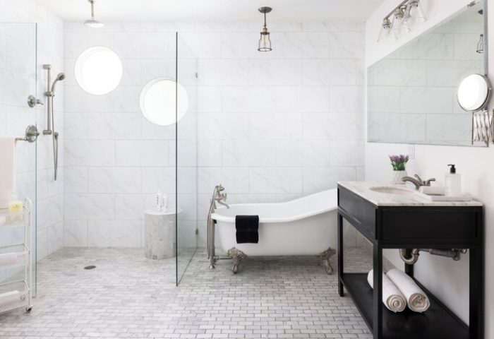 Bathroom at THE PALM SPRINGS HOTEL, a gay-friendly hotel. Features a clawfoot tub, walk-in shower, and modern design elements. Gay travel.