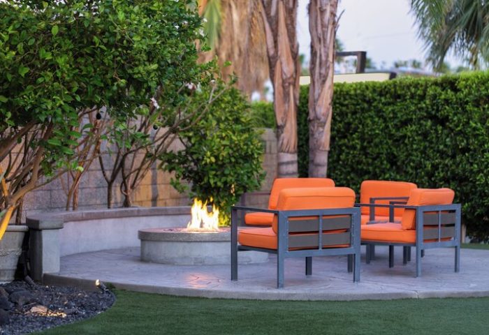 Palm Springs Hotel patio with fire pit & orange chairs. Gay-friendly hotel offers luxury & relaxation. Perfect for gay travelers seeking comfort.