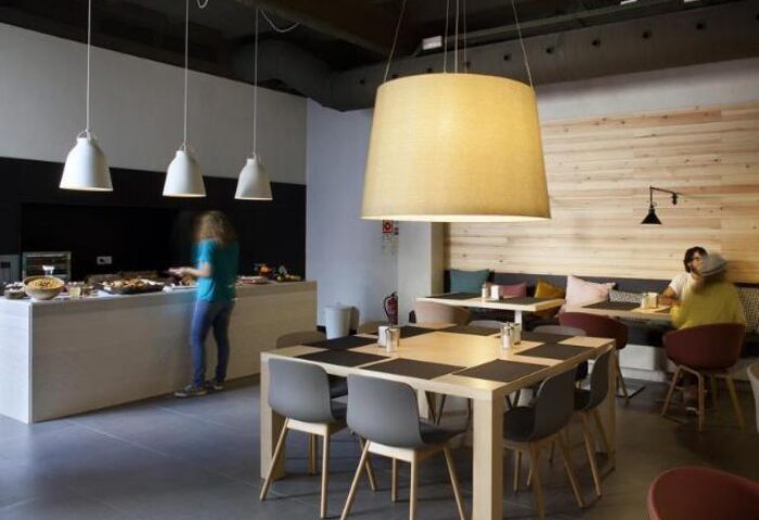 TOC Hostel Barcelona dining area. Gay-friendly hotel with buffet, tables, and modern lighting. A comfortable space for gay travelers.