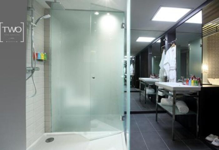 Bathroom at TWO Hotel Barcelona by Axel, a gay-friendly, adults-only hotel. Features a glass shower and modern sink area.