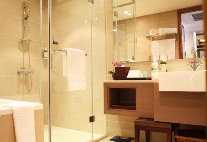 Bathroom at Taipei Garden Hotel, a gay-friendly hotel. Features a glass shower, sink, mirror, and scale. Ideal for gay men travelers.