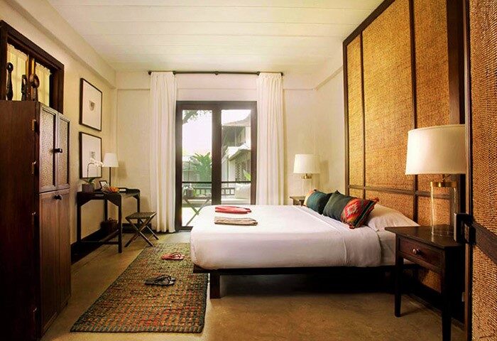 Tamarind Village Hotel bedroom. Gay-friendly hotel room with bed, desk, & woven headboard. Chiang Mai lodging for gay men's travel.