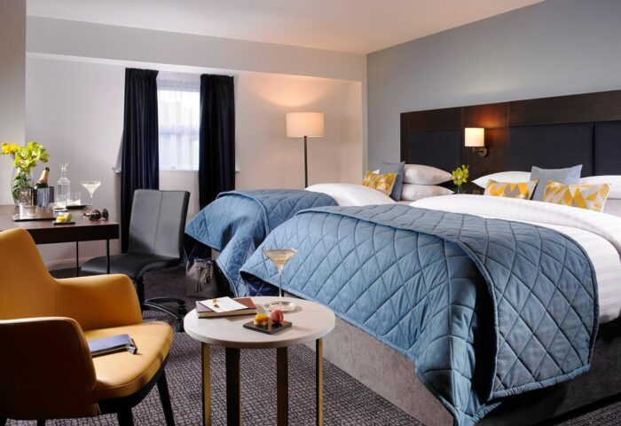 Gay-Friendly Temple Bar Hotel room with two beds, drinks, desk, and chair. Upscale decor for gay travel in Dublin, Ireland.