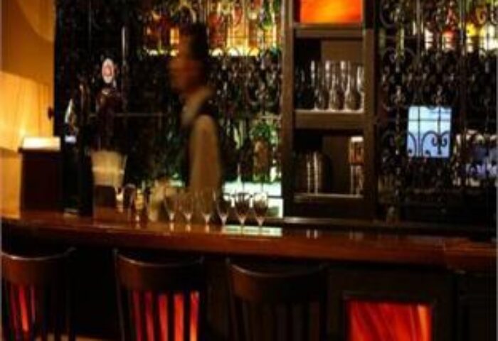 The bar at Temple Bar Hotel, a gay-friendly hotel. Barman, glasses, and bottles are visible. Dublin, Ireland.