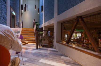 Temple Bar Inn, a gay-friendly hotel. Interior view with stairs, lighting, and a person reading. Dublin travel advice for gay men.