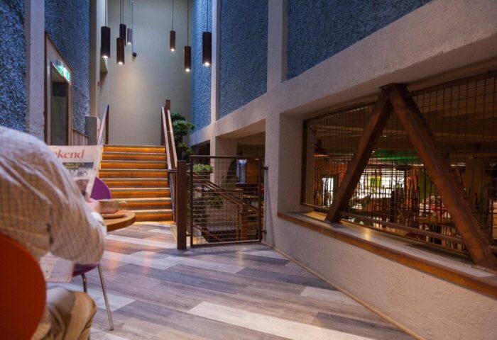Temple Bar Inn, a gay-friendly hotel. Interior view with stairs, lighting, and a person reading. Dublin travel advice for gay men.