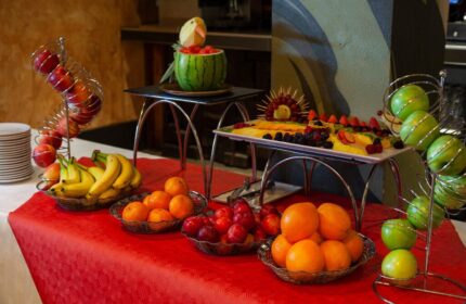 Fruit display at Temple Bar Inn, a gay-friendly hotel. Watermelon carving, fruit platters, apples, oranges, bananas, and plums on a red tablecloth.