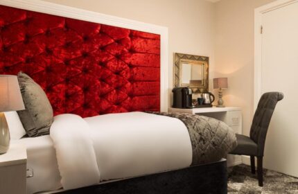 Temple Bar Lane Hotel room. Red velvet headboard, desk with coffee maker, chair. Gay-friendly lodging at KeyCollections Dublin.