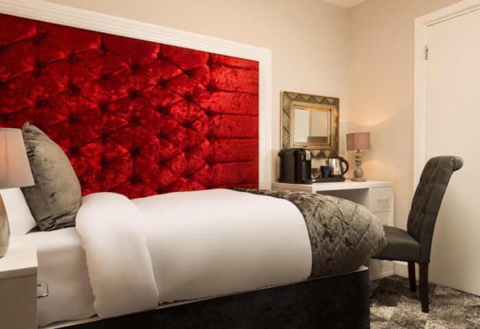 Temple Bar Lane Hotel room. Red velvet headboard, desk with coffee maker, chair. Gay-friendly lodging at KeyCollections Dublin.
