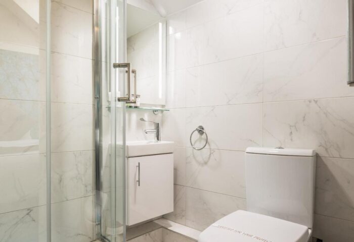 Temple Bar Lane by the KeyCollections gay-friendly hotel: bathroom with shower, sink, toilet, white marble tiles. Modern, clean design.