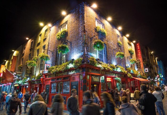 Temple Bar Lane by the KeyCollections: A gay-friendly hotel in Dublin, Ireland. The Temple Bar pub glows with lights at night, attracting crowds.
