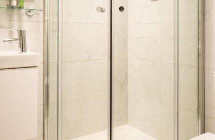Bathroom at Temple Bar Lane by the KeyCollections, a gay-friendly hotel. Features a glass shower, patterned floor, & modern fixtures.