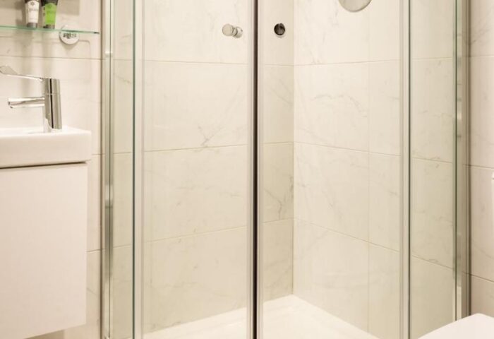 Bathroom at Temple Bar Lane by the KeyCollections, a gay-friendly hotel. Features a glass shower, patterned floor, & modern fixtures.