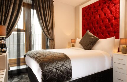 Temple Bar Lane by the KeyCollections gay-friendly hotel. Bedroom with red headboard, brown curtains, and plush bedding. Dublin gay travel.