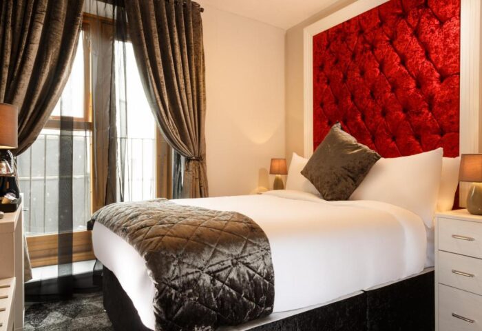 Temple Bar Lane by the KeyCollections gay-friendly hotel. Bedroom with red headboard, brown curtains, and plush bedding. Dublin gay travel.