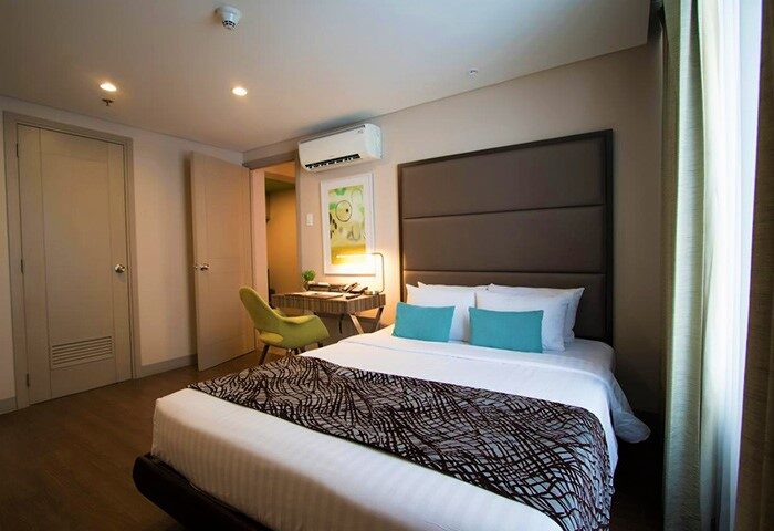 The A. Venue Hotel room. Gay-friendly hotel with a bed, desk, and modern decor. Ideal lodging for gay men's travel.