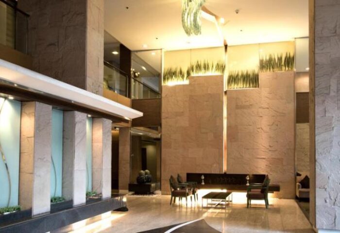 Lobby interior at The A. Venue Hotel, a gay-friendly hotel. Modern design with stone walls, plants, and marble floors. A great choice for gay travel.