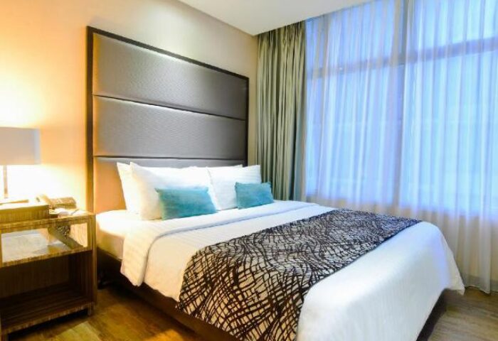 The A. Venue Hotel room. Gay-friendly hotel with a king-size bed, stylish headboard, and bedside table. Modern design. Great for gay travel.
